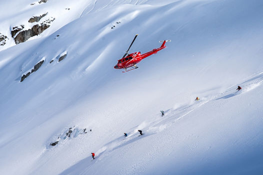 Skiers and Snowboarders Drop Into Deep Powder During a Helliskiing Adventure at Whistler Blackcomb