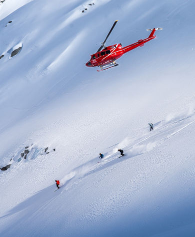 Skiers and Snowboarders Drop Into Deep Powder During a Helliskiing Adventure at Whistler Blackcomb