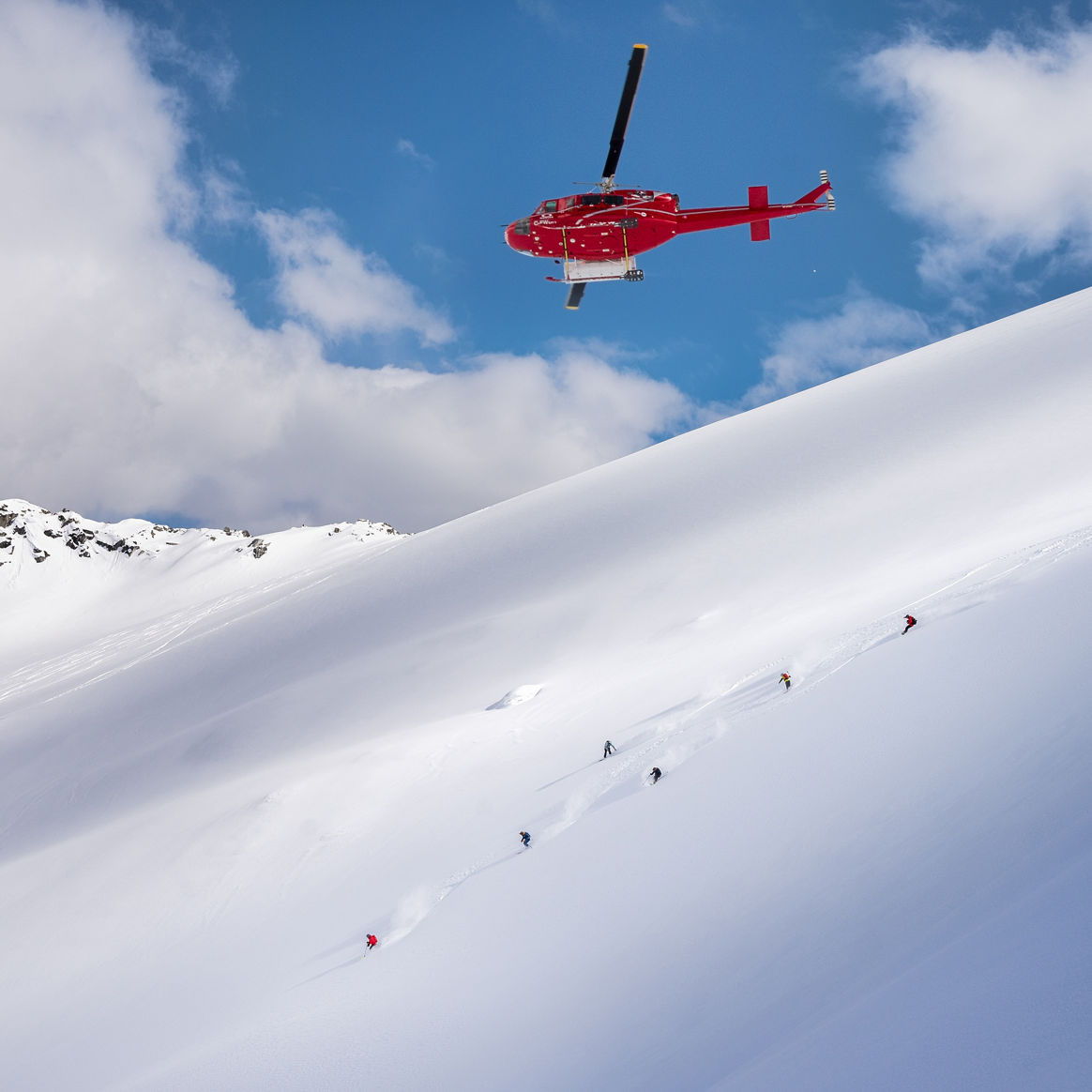 Skiers and Snowboarders Drop Into Deep Powder During a Helliskiing Adventure at Whistler Blackcomb