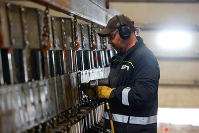 CBMR Vehicle Maintenance worker Re-Tracking a Snowcat During a Spring Off-Season Project