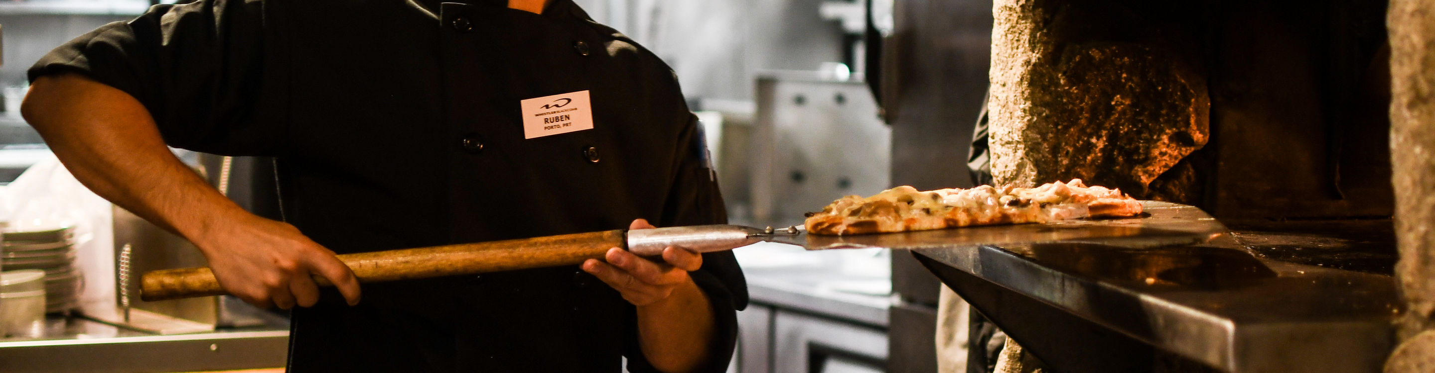 Employee Firing Flatbread Pizza at Merlin's Bar & Grill at Whistler Blackcomb