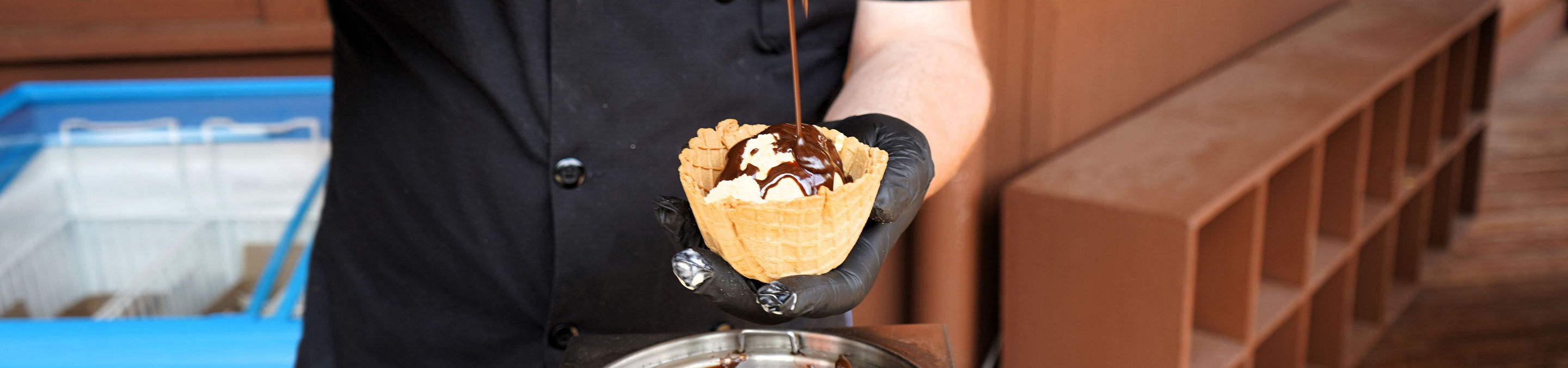 Employee Pouring Hot Fudge at Wildcat Ice Cream Social 2023 Event