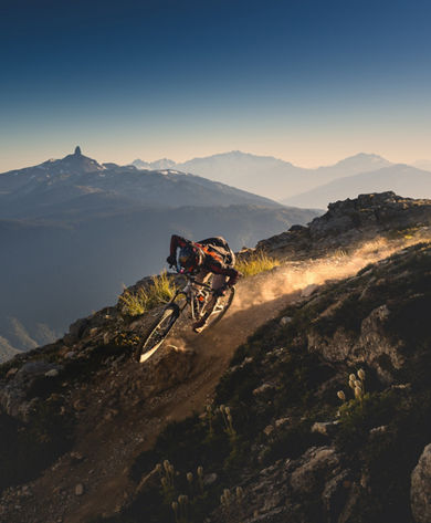Mountain Biker Riding on High Alpine Terrain with Black Tusk in the Background at Whistler Blackcomb