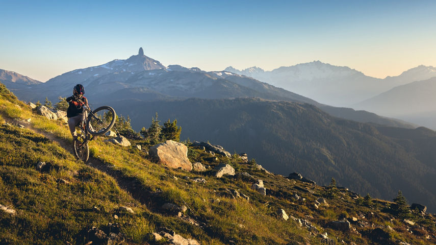 Mountain Biker Riding on High Alpine Terrain with Black Tusk in the Background at Whistler Blackcomb