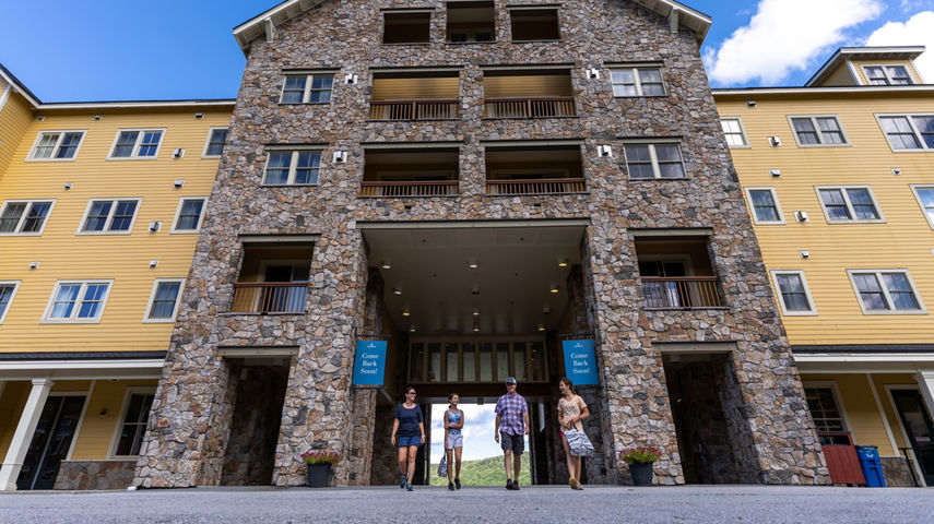 Family Walking Through Jackson Gore Inn Entryway at Okemo During Summer