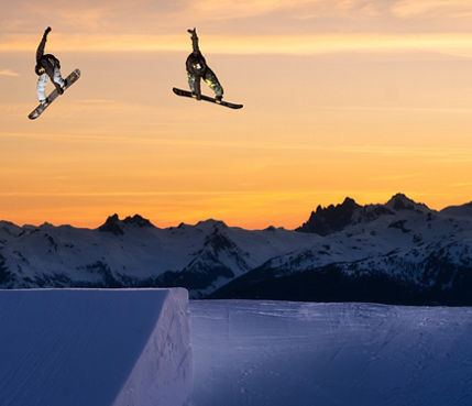 Snowboarders Jump at Sunset at Whistler Blackcomb Terrain Park