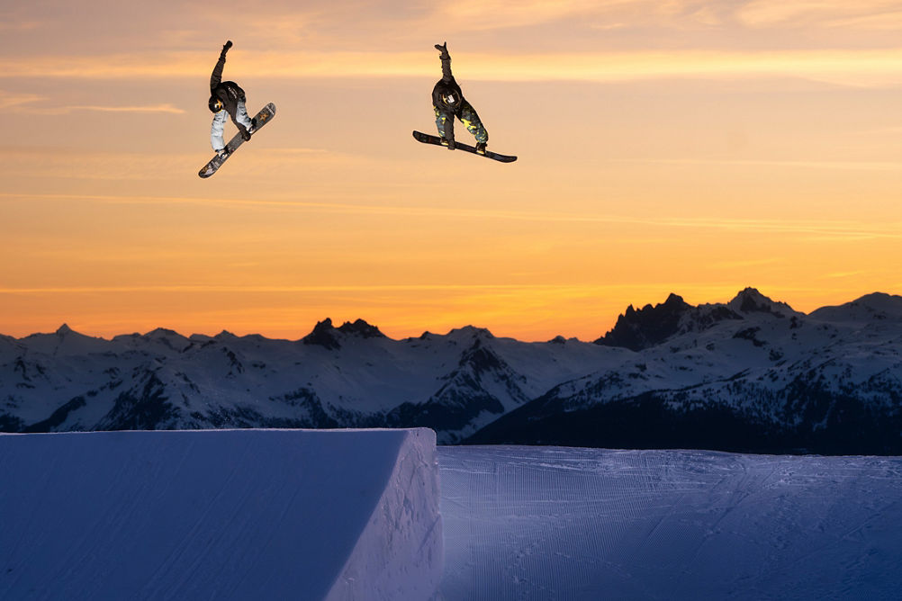 Snowboarders Jump at Sunset at Whistler Blackcomb Terrain Park