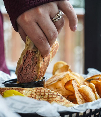 Guest Dips Sandwich at Wildcat Pub