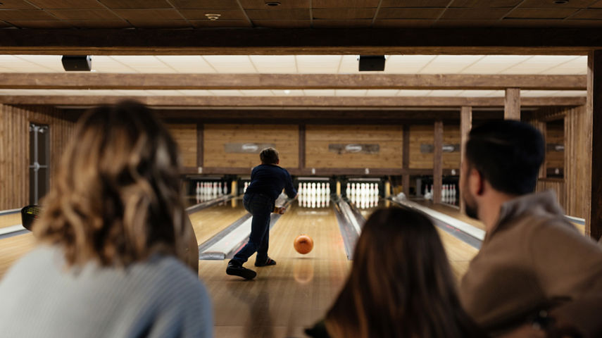 Son Sends Bowling Ball Down Alley at Family Bowling Activity at Seven Springs