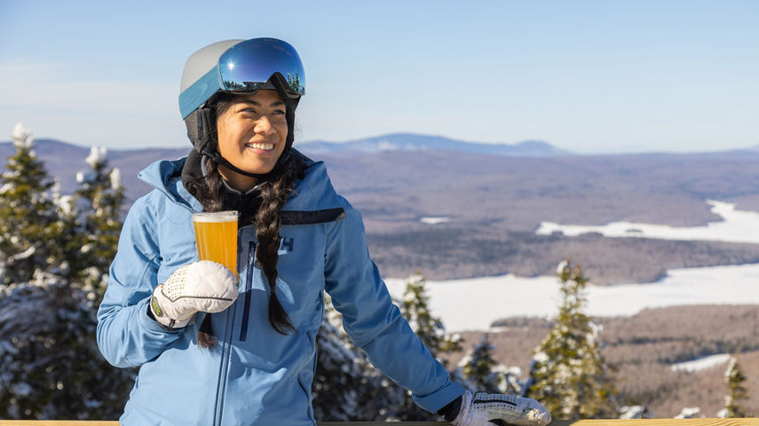 Woman Indulges in Apres Ski Overlooking Scenic Mount Snow