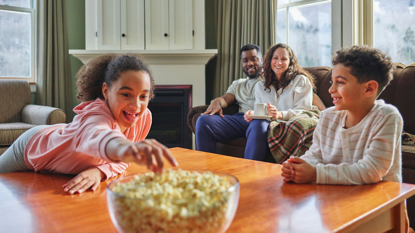 Family Relaxing on Couch on a Snowy Day in Okemo Lodge