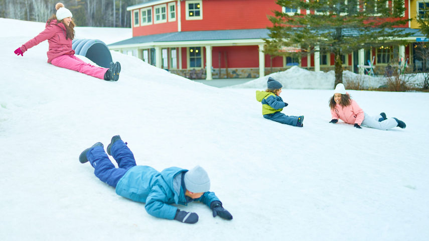 Family Slides Down Snowy Hill at Okemo