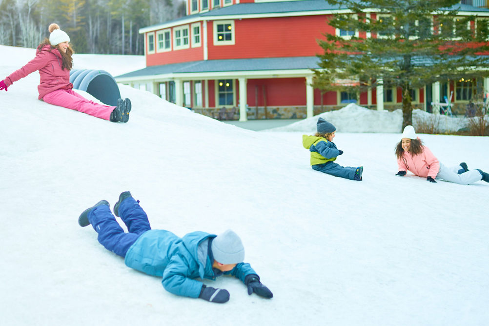 Family Slides Down Snowy Hill at Okemo