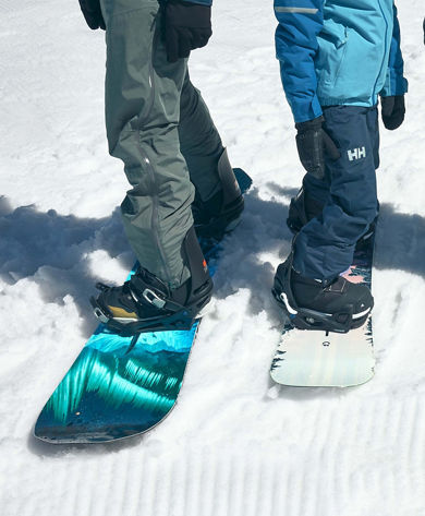 Guests Pose with Ski and Snowboard Gear on Groomed Snow