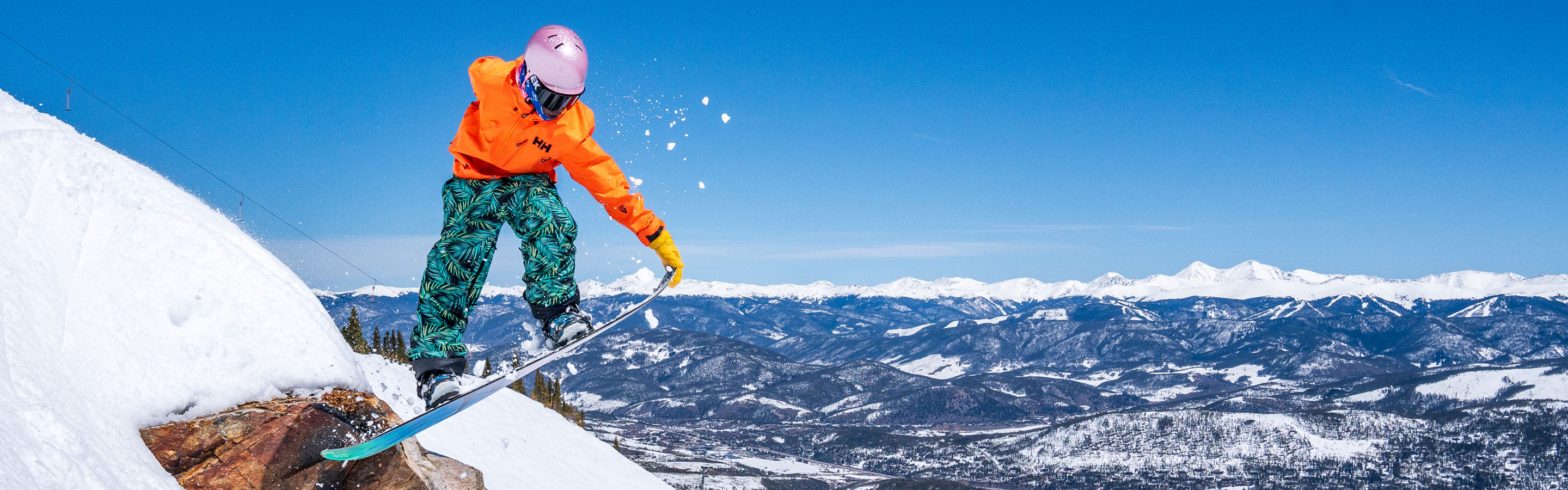 Snowboarder Jumping off Rock on Slope on a Bluebird Day at Breckenridge - CROPPED
