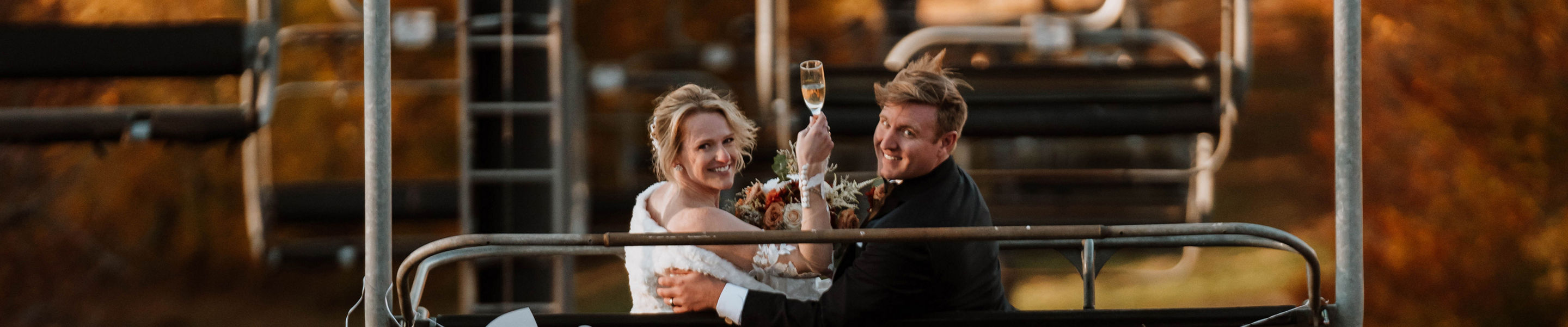 Bride and Groom Riding Chairlift Among Fall Foliage at Mount Sunapee