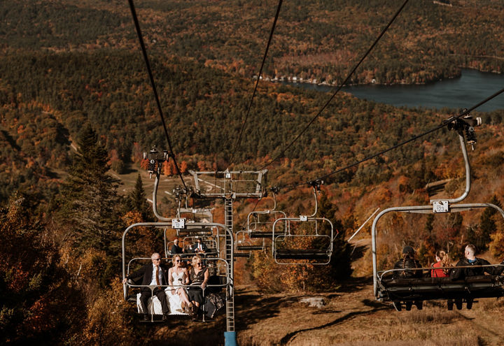 Bride and Groom Riding Chairlift Among Fall Foliage at Mount Sunapee