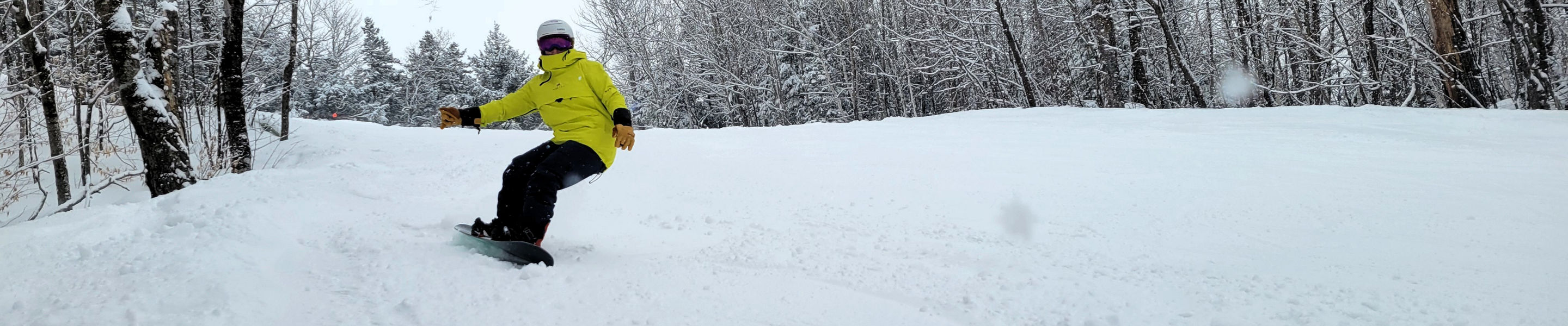 Guest Snowboarding Down Mountain at Attitash