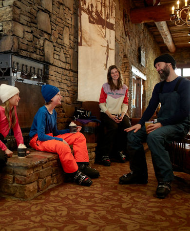 Family Huddles Around Fire in Lobby at Seven Springs 