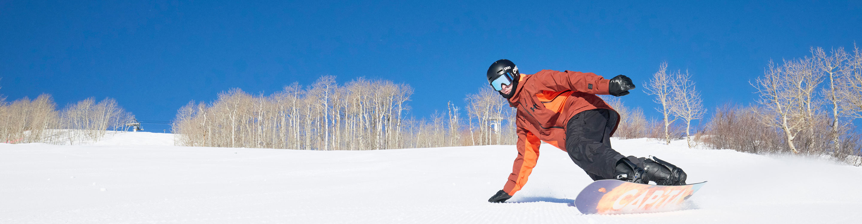 Snowboarder Carving Down Mountain at Park City