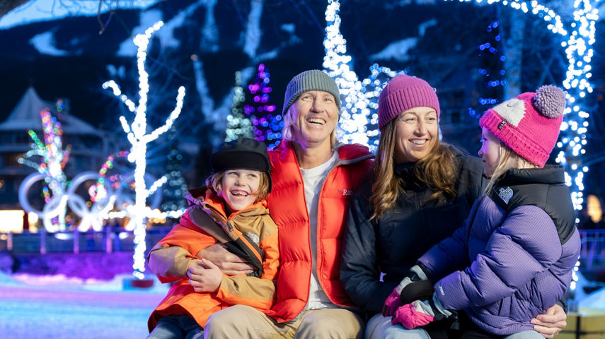 Family of Four Smiling under Lights at Whistler Blackcomb Village