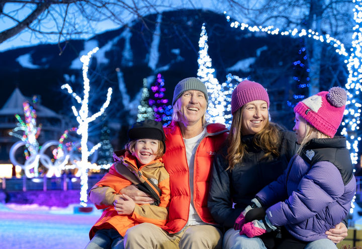 Family of Four Smiling under Lights at Whistler Blackcomb Village
