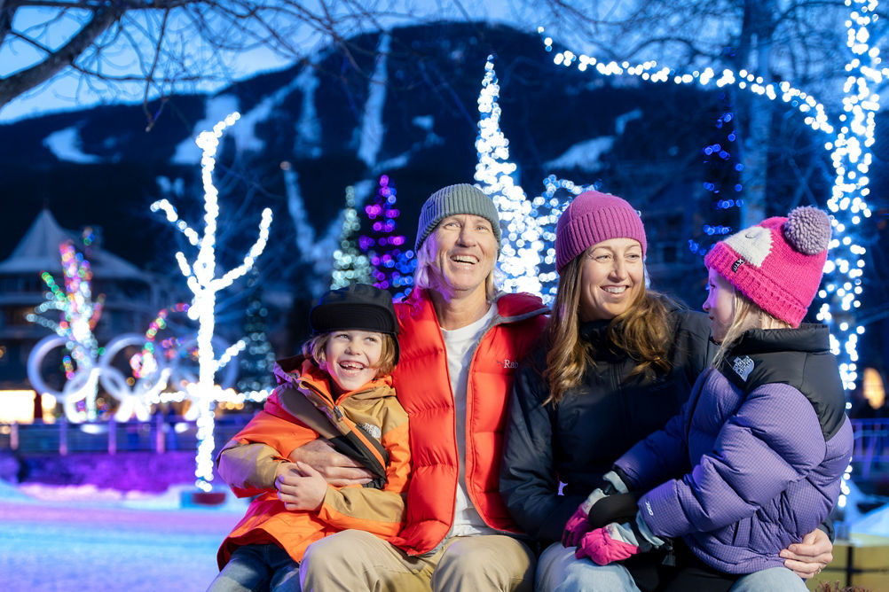 Family of Four Smiling under Lights at Whistler Blackcomb Village