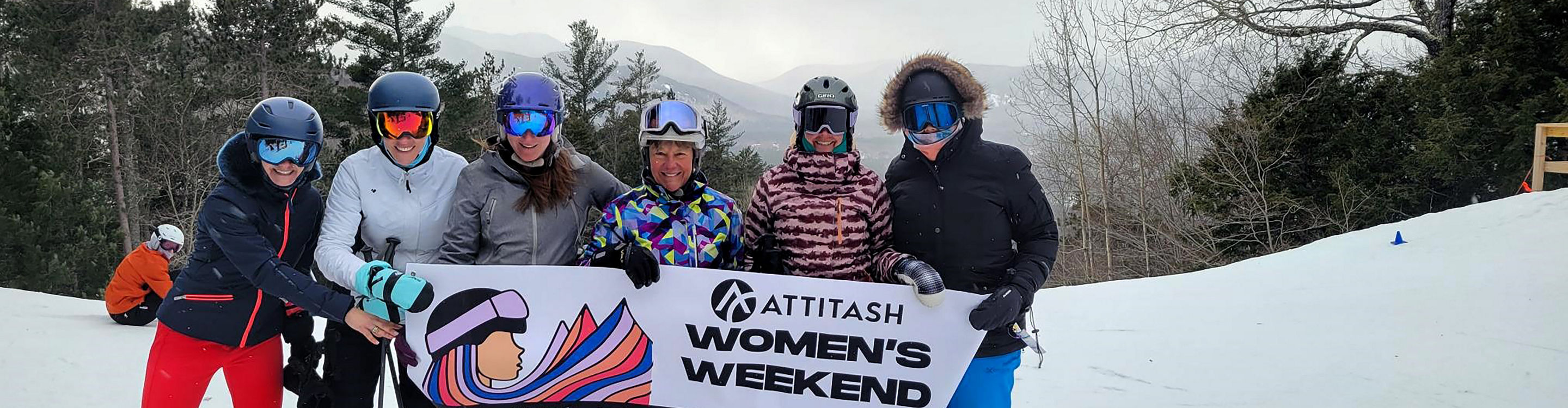 Women Pose with Banner at Attitash Women's Weekend 2025 Event