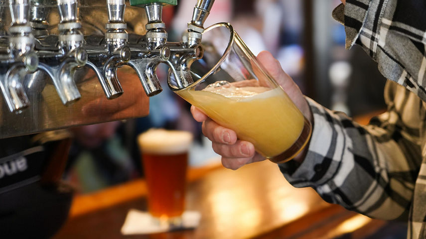 Man Pouring a Beer from Tap at The Den