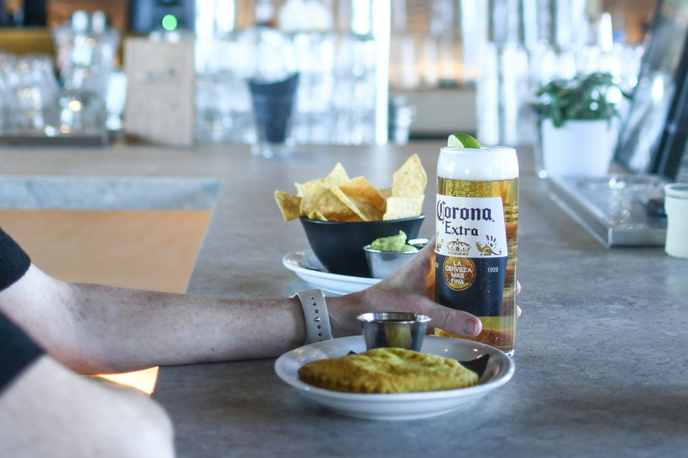 Bar patron enjoying Corona beer and appetizers at Seppo's Bar in Roundhouse Lodge
