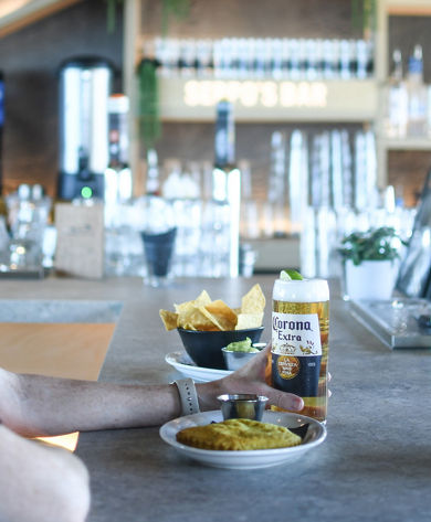 Bar patron enjoying Corona beer and appetizers at Seppo's Bar in Roundhouse Lodge