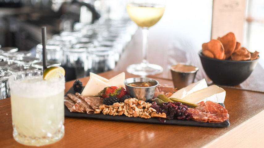 Meat and Cheese Board with a Glass of Wine a Cocktail and Chips at Umbrella Bar