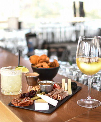 Meat and Cheese Board with a Glass of Wine a Cocktail and Chips at Umbrella Bar