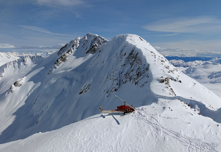 Helicopter on Snowy Peak in Remote Alpine Wilderness