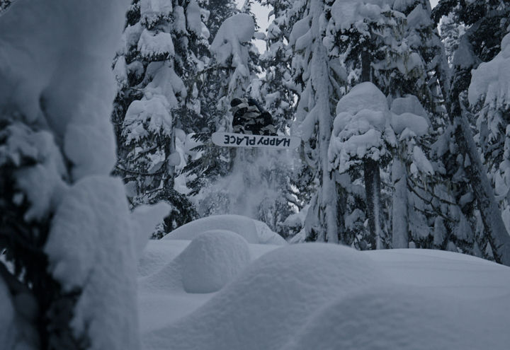 Snowboarder Launching Through Deep Forest Powder