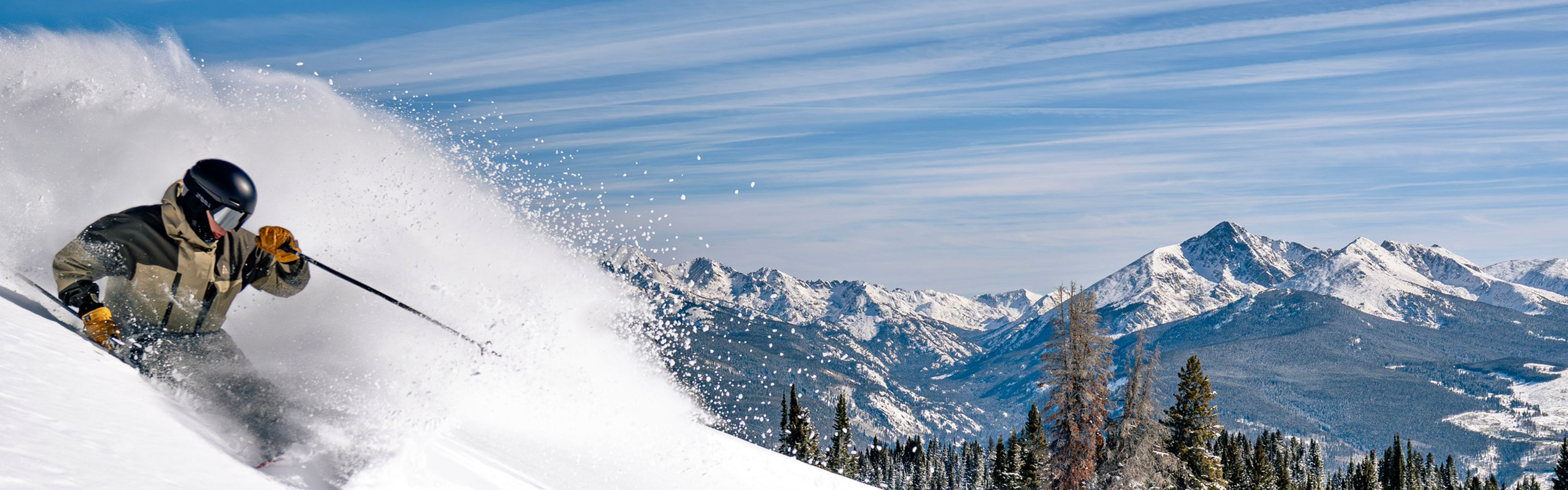 Dynamic Powder Turn with Mountain Backdrop at Vail
