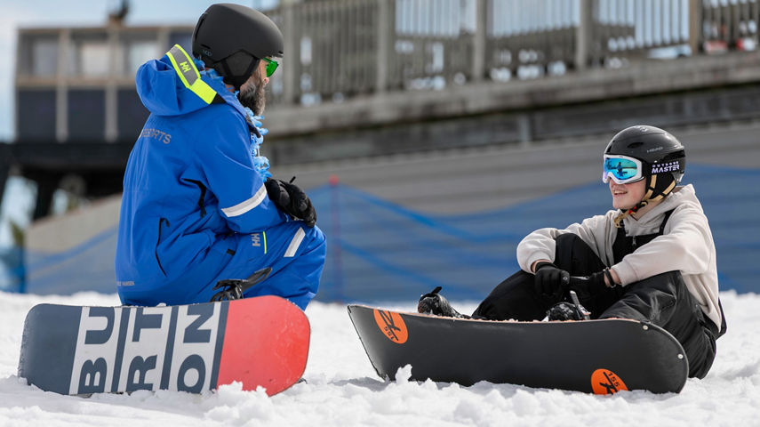 Snowboard instructor teaches a student
