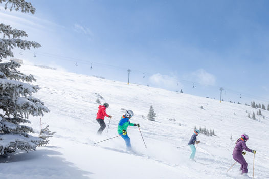 Family Skiing Down Slopes at Keystone