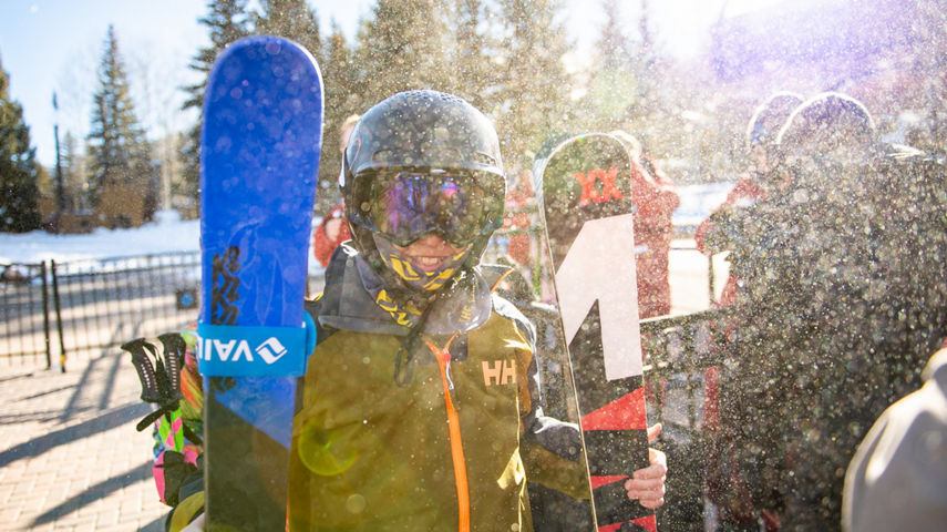 Skier holding skis wearing Helly Hansen gear