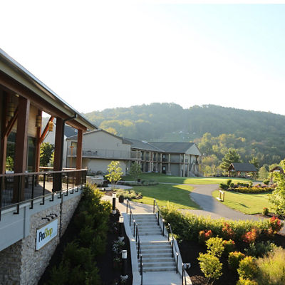 The Fairway Hotel glows in front of a green mountain at Liberty Mountain Resort