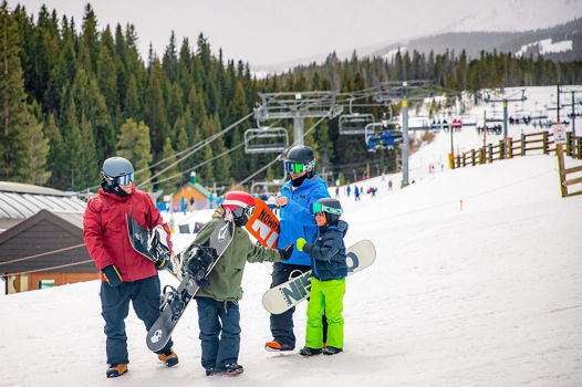 Friends with kids snowboard beginners near Quicksilver Peak 9
