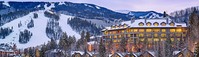 The Pines glowing at dusk next to a snow covered Crested Butte mountain. 