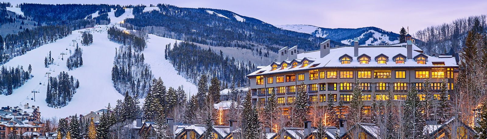 The Pines Lodge illuminated at dusk above Beaver Creek Village in winter.