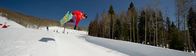 Snowboarder wearing a helmet rides a half pipe in the terrain park in Vail, Colorado
