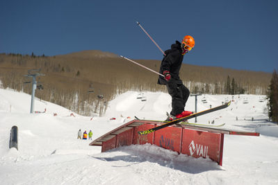 Skier wearing a helmet who understands SMART style rides a small feature in the Terrain Park in Vail, Colorado