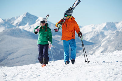 A couple travels uphill carrying their skis in Vail, Colorado